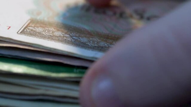 4K Finance extreme Close up of mans hand flicking through foreign currency forex banknotes. Global business international trade and finance concept 