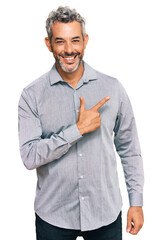 Obraz premium Middle age grey-haired man wearing casual clothes cheerful with a smile of face pointing with hand and finger up to the side with happy and natural expression on face