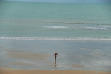 mulher caminhando na beira da praia em Japaratinga, alagoas