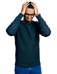 Fototapeta premium Young african american man wearing casual clothes and glasses suffering from headache desperate and stressed because pain and migraine. hands on head.