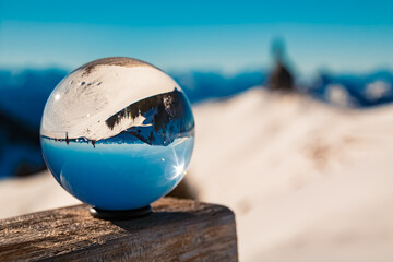 Crystal ball alpine winter landscape shot with a chapel at Mount Wallberg, Rottach-Egern, Lake Tegernsee, Miesbach, Bavaria, Germany - obrazy, fototapety, plakaty