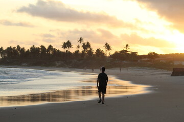 silhueta de homem não identificado caminhando na Praia da lagoa do Pau  (alagoas) ao amanhecer