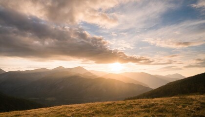 beautiful sunset in the mountains landscape with sun shining through orange clouds