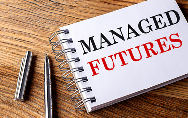 MANAGER FUTURES text on notebook with pen on the wooden background