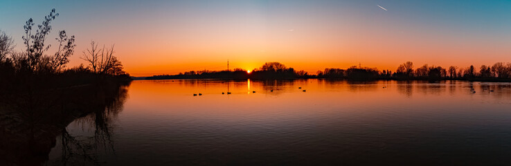 High resolution stitched winter sunset panorama with reflections and swans near Plattling, Isar,...