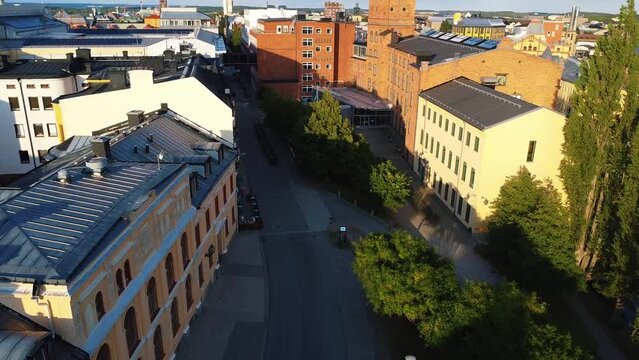 Drone of Norrkoping Campus buildings at sunset time with trees, empty road and blue sky in Sweden