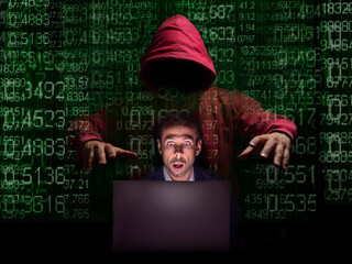 Hooded Figure Behind Laptop, Green Binary Code Background