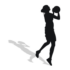 Image of black female silhouette of basketball player in a ball game.