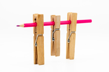 Pinzas de madera de la ropa de diferentes tamaños con un lápiz de color, aislado en blanco	