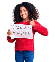 African american child with curly hair holding black lives matter banner smiling happy and...