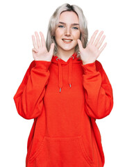 Young blonde girl wearing casual clothes showing and pointing up with fingers number nine while smiling confident and happy.