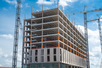 Double cranes working concrete building construction site, high-rise hotels, office building, skyscraper structure with precast concrete wall in downtown Irving, Texas, commercial real estate