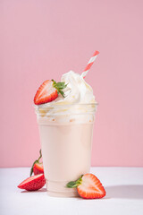 Strawberry milkshake or smoothie, summer fruit cocktail with fresh strawberries, on white pink...