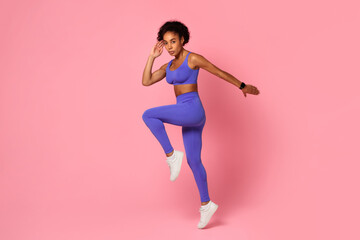 Fototapeta na wymiar Active African American woman exercising on pink