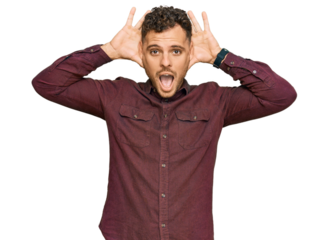 Young hispanic man wearing casual clothes smiling cheerful playing peek a boo with hands showing face. surprised and exited