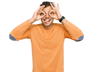 Young hispanic man wearing casual clothes doing ok gesture like binoculars sticking tongue out, eyes looking through fingers. crazy expression.