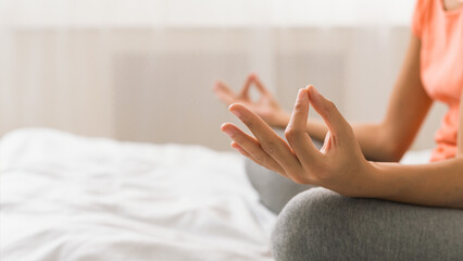 Woman doing yoga lotus pose on bed after wake up