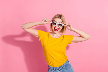 Photo of cheerful carefree lady dressed yellow t-shirt hands arms dark eyewear smiling isolated pink color background