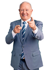 Senior handsome grey-haired man wearing elegant suit pointing fingers to camera with happy and...