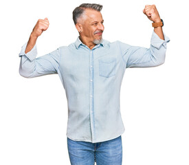 Middle age grey-haired man wearing casual clothes showing arms muscles smiling proud. fitness...