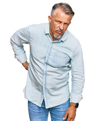Fototapeta premium Middle age grey-haired man wearing casual clothes suffering of backache, touching back with hand, muscular pain