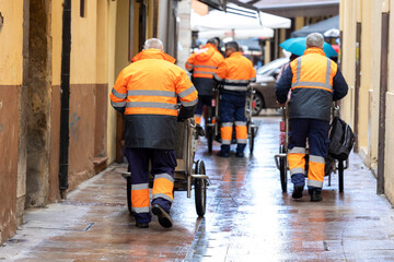 Men with brooms and cleaning carts walk the streets, removing waste and keeping the city clean.