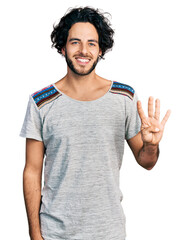 Young hispanic man wearing casual t shirt showing and pointing up with fingers number four while...