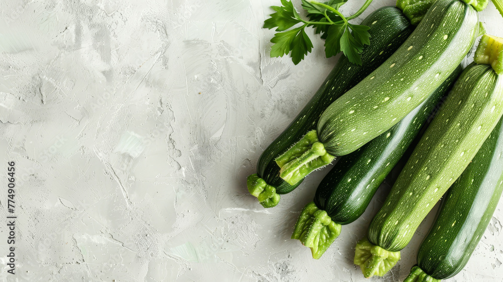 Poster Fresh zucchinis with lush leaves on a grey concrete surface.