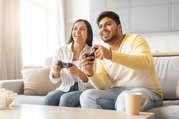 Indian Man and Woman Playing Video Game on Couch