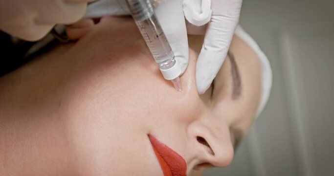 Crop beautician doing collagen injection to client. Biorevitalization. Mesotherapy. Beauty injections.