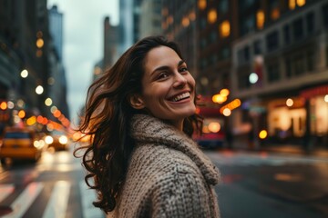 Happy young woman in the street of New York city at sunset.
