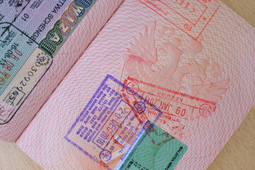 close up part of pages of foreign passport with foreign visas, border stamps, permits to enter...