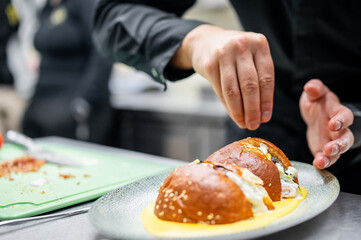 A chef meticulously garnishes a gourmet dish, adding the final artistic touch that elevates it to a masterpiece