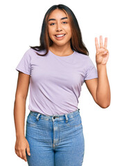 Young latin woman wearing casual clothes showing and pointing up with fingers number three while smiling confident and happy.