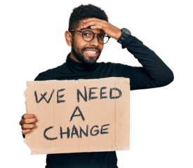 Young african american man holding we need a change banner stressed and frustrated with hand on head, surprised and angry face