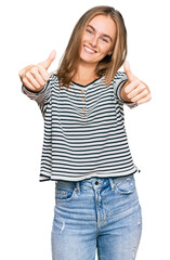 Beautiful blonde woman wearing casual clothes approving doing positive gesture with hand, thumbs up smiling and happy for success. winner gesture.
