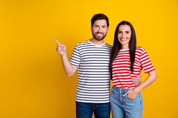 Photo portrait of lovely young couple hugging point empty space promo wear trendy striped garment...