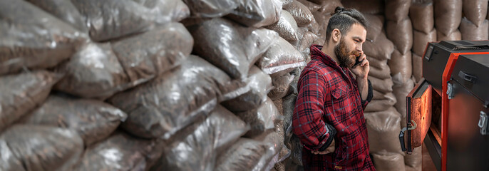 A man with a solid fuel boiler, working on biofuel, economical heating.