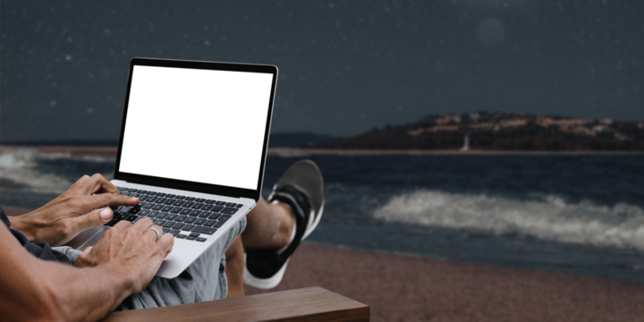 a man works in nature, sitting in a chair with a laptop