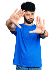 Fototapeta premium Young arab man with beard wearing casual blue t shirt doing frame using hands palms and fingers, camera perspective