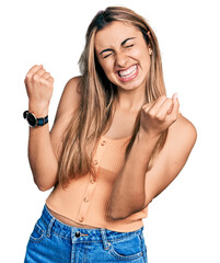 Hispanic young woman wearing casual summer shirt excited for success with arms raised and eyes closed celebrating victory smiling. winner concept.