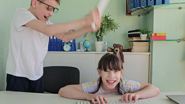 Girl child teenager furiously swings keyboard, hitting friend of classmate on the head in anger and disappointment, demonstrating violence at school. Children brother sister swear computer addiction o