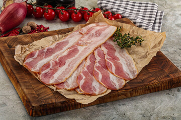 Sliced pork bacon over board