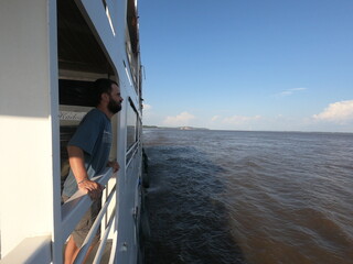 homem em barco no rio amazonas fazendo o trajeto do pará ao amapá 