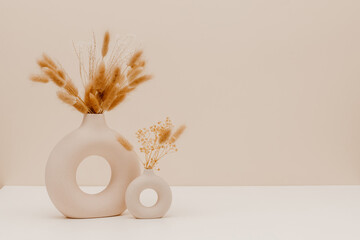 Still life aesthetic composition. Ceramic vase set with dry bunny tail and pampas grass bouquet on...