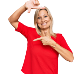 Middle age caucasian woman wearing casual clothes smiling making frame with hands and fingers with happy face. creativity and photography concept.