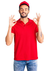 Naklejka premium Young handsome hispanic man wearing delivery courier uniform relax and smiling with eyes closed doing meditation gesture with fingers. yoga concept.
