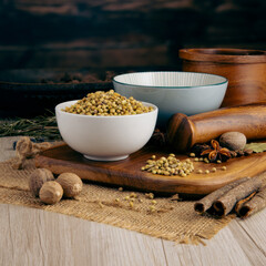 CORIANDER SEEDS on wooden table background. Herbs, spices and dried food baking ingredient. Mortar and different spices. Cottage kitchen. Product Photography