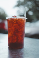 Thai black tea in clear plastic take away cup with straw