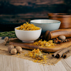 MARIGOLD FLOWERS DRIED on wooden table background. Herbs, spices and dried food baking ingredient....